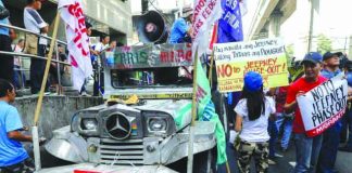 Demonstrators hold signs protesting against the government’s plan to phase-out old jeepneys. Transport groups will push through their planned nationwide strike on Monday. UNTV