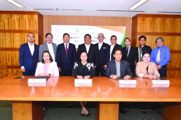 Landbank LANDBANK President and CEO Cecilia C. Borromeo (seated, 2nd from left) and Agriculture Acting secretary William D. Dar (seated, 3rd from left) sign a MOA with LBP Lending Program Management Group head/FVP Emellie Tamayo (seated, extreme left) and Agricultural Credit Policy Council (ACPC) executive director Jocelyn Alma Badiola (seated, extreme right), witnessed by Agrarian Reform secretary John Castriciones (standing, 4th from left), with Deputy Treasurer Atty. Erwin Sta. Ana (standing, extreme left), LBP directors Jesus Hinlo Jr., Jaime Miralles, and Virgilio Robes Jr., Agriculture undersecretary Atty. Francisco Villano Jr., and ACPC deputy executive director Ramon Yedra (standing, extreme right).