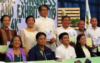 Agriculture Assistant Secretary Rene Famoso (seated, 2nd from left) and representatives of the National Organic Agriculture Program and Agriculture Training Institute pose with the awardees from Negros Occidental, including integrated and organic farmer Jesus Antonio Orbida (standing, 3rd from left), during the 2019 Regional Organic Agriculture Achievers’ Awards held in Iloilo City on Sept. 17. CHECCS OSMEÑA-ORBIDA VIA PNA