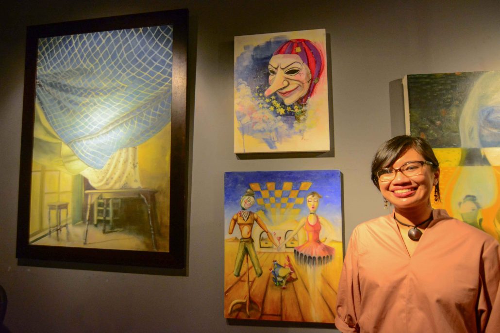 Yuhum Muriel Dean stands beside her art piece at Omriel Art Gallery.