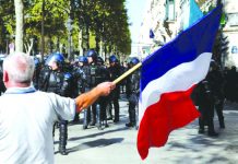 A protester holds a French flag as he takes part in a demonstration on Act 25 (the 45th consecutive national protest on Saturday) of the yellow vests movement in Paris, France , Sept. 21, 2019. REUTERS