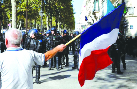 Paris climate rally A protester holds a French flag as he takes part in a demonstration on Act 25 (the 45th consecutive national protest on Saturday) of the yellow vests movement in Paris, France , Sept. 21, 2019. REUTERS