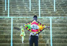 Zimbabwe’s Mugabe to be honored at state funeral A man in the stands holds a banner with the face of former president Robert Mugabe, as members of the public queue up to view his body at the Rufaro stadium in the capital Harare, Zimbabwe Friday, Sept. 13, 2019. AP