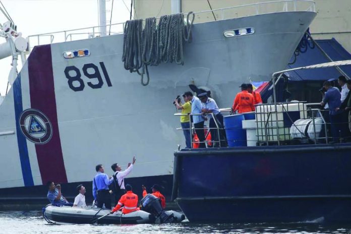 In this May 28, 2013, file photo, Taiwanese investigators ride a rubber boat as they inspect a ship involved in the alleged shooting of a Taiwanese fisherman while they continue their probe in Manila, Philippines. A Philippine court found eight Filipino coast guard personnel guilty Wednesday, Sept. 18, 2019 of conspiring to shoot and kill a Taiwanese fisherman in a 2013 incident at sea that strained ties between the neighboring nations. AP