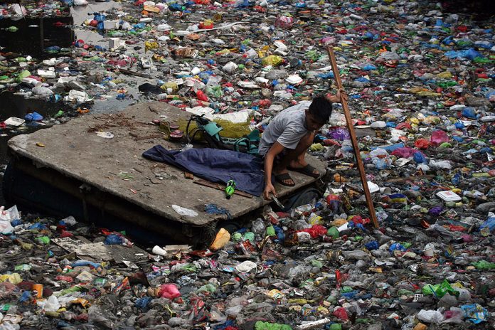A scavenger uses a make-shift raft to collect reusable plastic from a river of trash and other debris in Binondo, Manila on Wednesday, April 22, a day after a thunderstorm brought heavy rains in Metro Manila. GMA NEWS