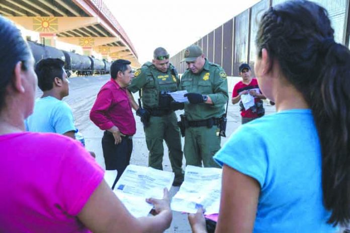 US Customs and Border Protection US Customs and Border Protection agents in May 2019 check documents in El Paso, Texas, from a small group of migrants who crossed from Mexico. AFP