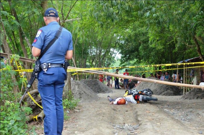 farmer shot dead AMBUSH SITE. A policeman inspects this crime scene in Barangay Cabugao Norte, Santa Barbara, Iloilo where a farmer was fatally ambushed while driving his motorcycle yesterday morning, Sept. 11, 2019. Probers say the attack could have been sparked by a land dispute. IAN PAUL CORDERO/PN