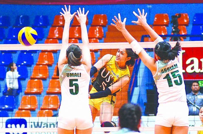 University of Santo Tomas Golden Tigresses’ Imee Hernandez smashes the ball towards two College of St. Benilde Lady Blazers defenders. SPORTS VISION PHOTO