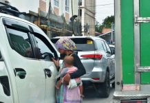 BEGGING FOR HELP.Carrying a baby, a Badjao beggar knocks on the window of a vehicle stuck in traffic in Barangay Ungka, Jaro, Iloilo City. The city government plans to transport back to Sulu all Badjao mendicants. Also called “sea gypsies”, many Badjaos have been displaced by decades of conflict in Mindanao. IAN PAUL CORDERO
