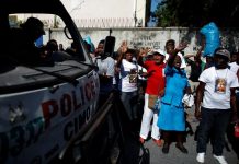 People shout next to a police truck outside the Christ Roi Church before a march was organized in Port-au-Prince, Haiti on Oct. 22. REUTERS/ANDRES MARTINEZ CASARES