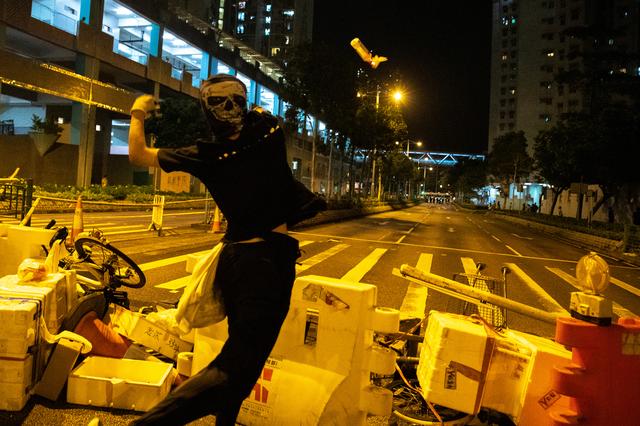 Hong Kong Protest An anti-government protester throws a cocktail toward police officers during a protest at Tseung Kwan O district in Hong Kong, China on Oct. 13. REUTERS/ATHIT PERAWONGMETHA
