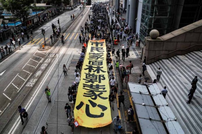 People march with a banner to protest against “the abuse of pro-democracy protesters by police,” near Chater Garden in Central district, Hong Kong, China on Oct. 18. REUTERS/AMMAR AWAD