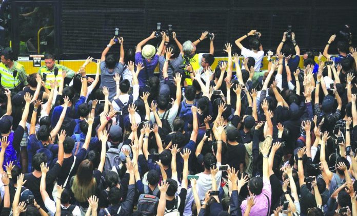 Hong Kong protest Supporters surround a police bus carrying political activist Edward Leung as it leaves the High Court in Hong Kong, Wednesday, Oct. 9, 2019. AP