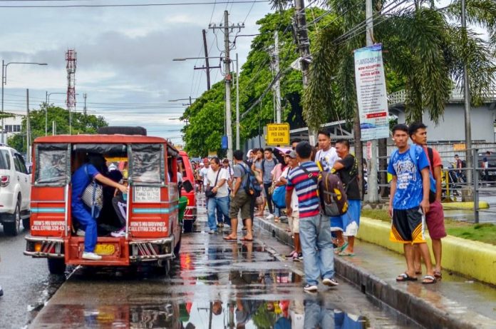 JEEPNEY RIDE. An Iloilo City-bound public utility jeepney picks up passengers gathered in front of a transport terminal in Barangay Buhang, Jaro district. The jeepney started as remodeled army vehicles left behind by US forces after World War II. Mainly patronized by low- to middle-income passengers, it has become the core of Philippine public transport. IAN PAUL CORDERO/PN