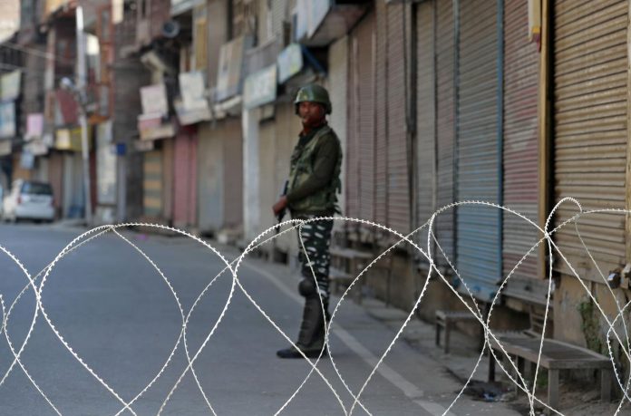 A security force officer stands guard in front of closed shops during restrictions following scrapping of the special constitutional status for Kashmir in Srinagar, India on Sept. 10. REUTERS/DANISH ISMAIL