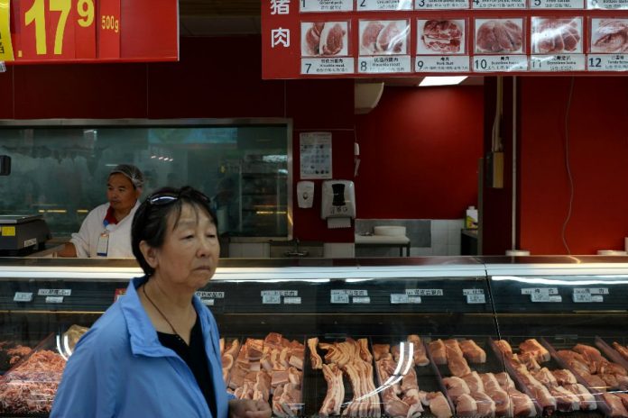 Inflation in china A woman walks past a pork counter at a Walmart in Beijing, China Sept. 23. TINGSHU WANG/REUTERS