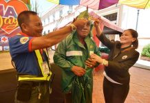 FOR SERVICE, RAIN OR SHINE. Iloilo City’s Rep. Julienne “Jam” Baronda helps a traffic aide put on a raincoat. A total of 291 traffic aides received rain protective gears from the city’s first congresswoman to shield them from inclement weather while on duty. IAN PAUL CORDERO/PN