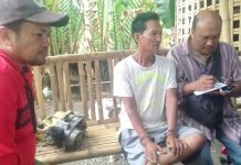 Aklan local arrested for ‘illegal gun possession’ Jimmy Ramos (second from right) sits handcuffed after he was arrested for illegal possession of firearm in Barangay Jalas, New Washington, Aklan last week. RADYO TODO/PN