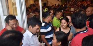 SHARING. Sen. Manny Pacquiao, accompanied by Bacolod City’s Mayor Evelio Leonardia and Cong. Greg Gasataya, shares his blessings to Bacolodnons by distributing financial assistance at the lobby of the Bacolod City Government Center on Oct. 17, 2019. BACOLOD CITY PIO