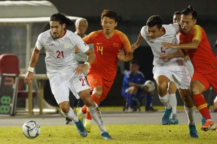 Mark Hartmann of the Philippines controls the ball while being chased by Chinese players. PFF PHOTO