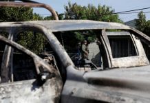 A soldier is seen near the burnt wreckage of a patrol car after an ambush by suspected cartel on police officers in El Aguaje, Michoacan state, Mexico on Oct. 14. REUTERS/ALAN ORTEGA