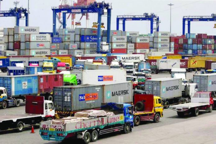 Trucks transporting containers with imported items are prepared to leave a port in Manila. REUTERS