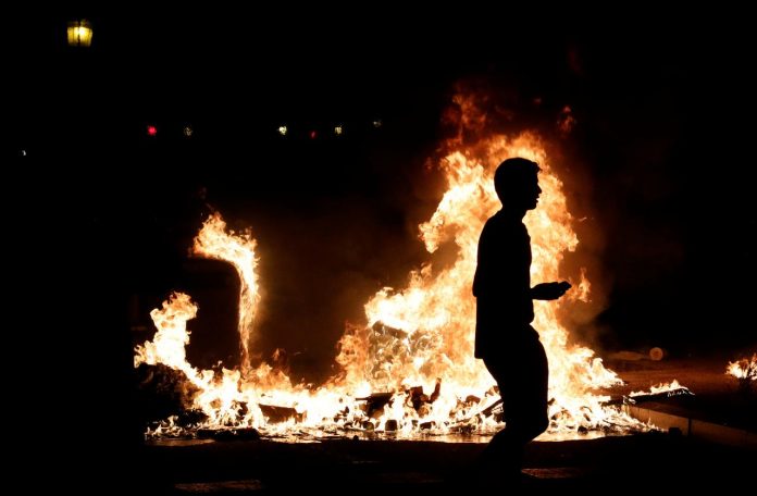 Protest sets Barcelona streets on fire A demonstrator walks past a fire during a protest in Barcelona, Spain on Oct. 16. REUTERS/ALBERT GEA