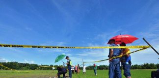 Policemen inspect the body of a farmer found dead in this rice paddy in Santa Barbara, Iloilo on Oct. 9, 2019. IAN PAUL CORDERO/PN