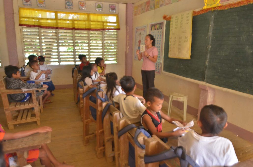 Combined Grade 2 and Grade 3 pupils listen attentively to their teacher Flordeluna Monares.