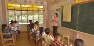 Combined Grade 2 and Grade 3 pupils listen attentively to their teacher Flordeluna Monares.
