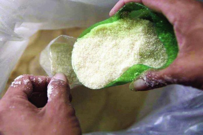 A man repacks sugar in packets on sale at a public market in Taguig City. REUTERS