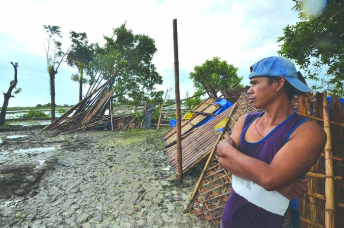 This man looks at the ruins of his house that was destroyed when a tornado ripped through Barangay Dawis Norte, Zarraga, Iloilo on Thursday. IAN PAUL CORDERO