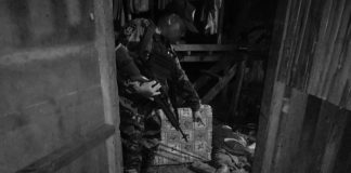 An officer points at the lifeless body of resident Lito Bawa-an, who was hacked and stabbed to death, in Barangay San Jose, Sipalay City, Negros Occidental on Nov. 21. SIPALAY CITY POLICE STATION