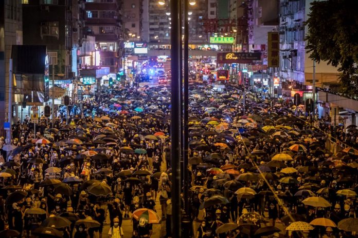 HK Recession Demonstrators walk on the street during a protest in Hong Kong. PAUL YEUNG/BLOOMBERG