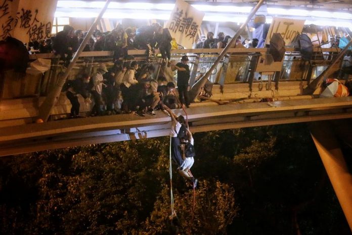 Anti-government protesters trapped inside Hong Kong Polytechnic University abseil onto a highway and escape before being forced to surrender during a police besiege of the campus in Hong Kong, China on Nov. 18. HK01/HANDOUT VIA REUTERS