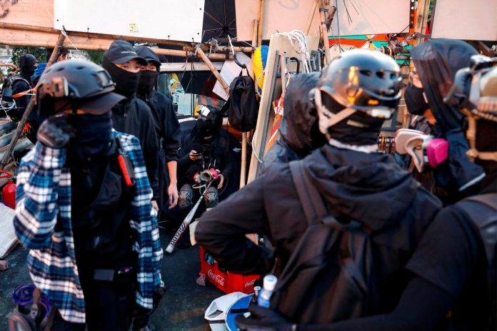 Hong Kong to shut schools amid protests Anti-government protesters scout at a makeshift gate during a standoff with riot police at a university in Hong Kong, China on Nov. 14. REUTERS/TYRONE SIU