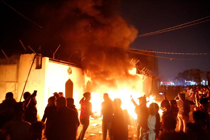 Demonstrators set fire in front of the Iranian consulate, as they gather during anti-government protests in Najaf, Iraq on Nov. 27. REUTERS/STRINGER