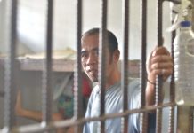 Pavia local falls in drug buy-bust Drugs suspect Jerry Joaquin of Barangay Aganan, Pavia, Iloilo sits handcuffed inside Jaro police station. CONTRIBUTED PHOTO