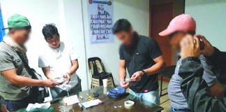 Antidrug operatives inspect the seized sachets of suspect shabu from Mark Andrew Panganiban (2nd from the left). PDEA REGION 6