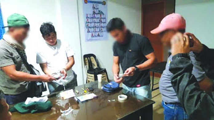 Antidrug operatives inspect the seized sachets of suspect shabu from Mark Andrew Panganiban (2nd from the left). PDEA REGION 6
