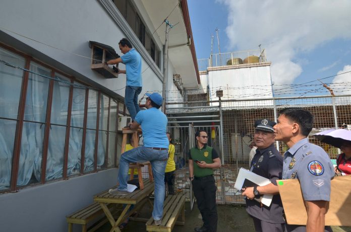 FIELD INSPECTION. Technical personnel of the National Telecommunications Commission check a phone signal jammer, installed outside the main building of the Iloilo District Jail in Barangay Nanga, Pototan, Iloilo. Residents within the 300-meter radius of the prison facility claim they cannot send text messages or make phone calls or use the internet adequately due to the phone signal jammers. The Bureau of Jail Management and Penology requires all jails with over 1,000 inmate-population to have phone signal jammers. The Iloilo District Jail currently has a population of 1,529 inmates. IAN PAUL CORDERO/PN