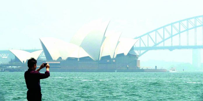 Smoke Sydney The smoke covered Sydney city Opera House and Harbour Bridge are seen as a man takes a picture at Mrs Macquarie's Chair on Sydney Harbour on Nov. 19, 2019 in Sydney, Australia.GETTY IMAGES