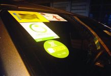 Stickers are seen on a car’s windshield