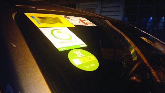Stickers are seen on a car’s windshield Stickers are seen on a car’s windshield