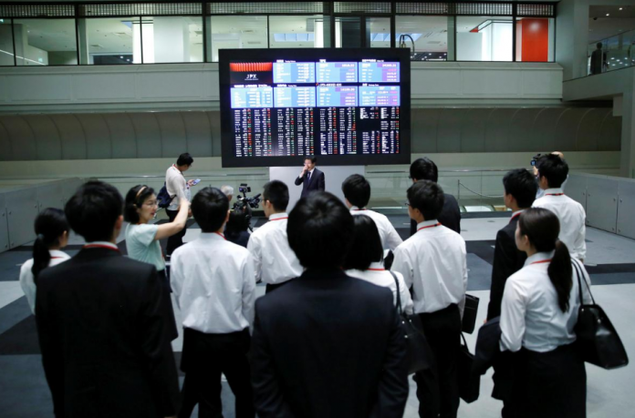 electronic stock shares Visitors look at an electronic stock quotation board at the Tokyo Stock Exchange in Tokyo, Japan. Asian shares lumbered lower on Wednesday as trade talks produce nothing but a stream of conflicting messages, while concerns about a glut of supply saw oil prices suffer their biggest spill in seven weeks. TORU HANAI/REUTERS