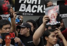 Campaigners in Manila hold pictures of victims as they mark the 10th anniversary of the massacre of 58 people, on November 23, 2019. AP