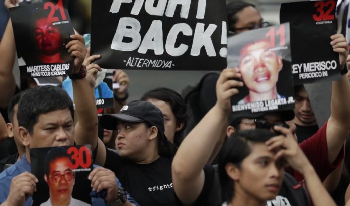 Ampatuan Massacre Campaigners in Manila hold pictures of victims as they mark the 10th anniversary of the massacre of 58 people, on November 23, 2019. AP