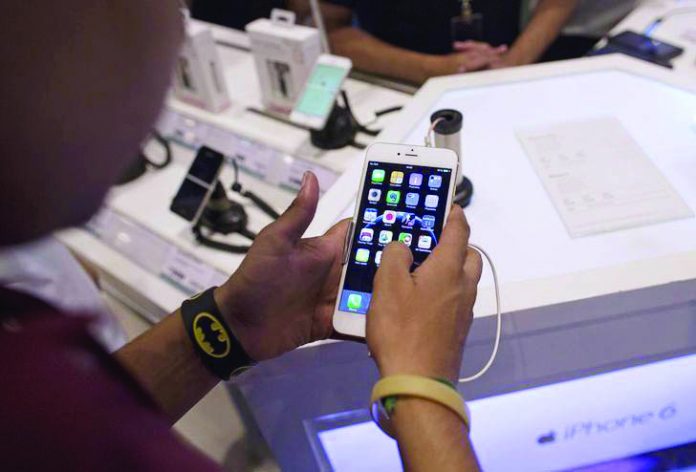 Apple iPhone 6 Plus A man inspects the Apple iPhone 6 Plus at an electronics store. The value of digital payments in the Philippines has jumped from eight percent in 2013 to 20 percent in 2018. REUTERS