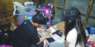 An antidrug operative inspects the suspected shabu seized from “high-value” target Arlene Arnaiz in Barangay 3, Bacolod City on Wednesday. Police Station 8/BCPO