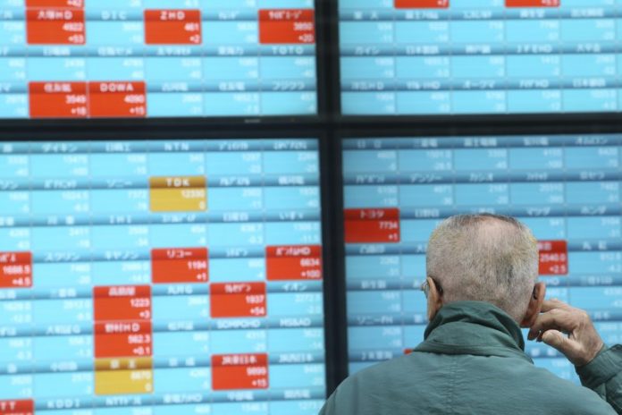 Asian shares A man looks at an electronic stock board of a securities firm in Tokyo, Dec. 30, 2019. Asian shares were mostly lower Monday as investors awaited updates on the signing of a trade deal between the United States and China and kept a wary eye on North Korea. AP